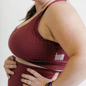 Fig colored maternity activewear nursing sports bra with mesh-back design and an adjustable band with hooks.