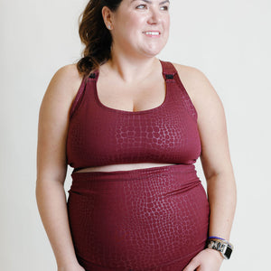 Fig colored maternity activewear nursing sports bra with mesh-back design and an adjustable band with hooks.